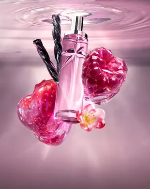 Stillleben des neuen Starlicious Berry Licorice mit dem schlanken Flakon, umgeben von seinen wichtigsten Inhaltsstoffen: eine glänzende rote Erdbeere, eine leuchtende Himbeere, eine zarte rosa Blüte und gedrehte schwarze Lakritzstangen vor einem sanft rosa schimmernden Wasserhintergrund.