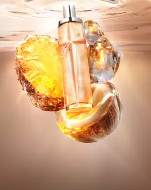 Stillleben des neuen Starlicious Pineapple Musk mit dem schlanken Flakon, umgeben von seinen wichtigsten Inhaltsstoffen: eine leuchtende Ananasscheibe, eine aufgebrochene Kokosnussschale und kristalliner Moschus vor einem warmen, leuchtenden Hintergrund aus sanft schimmerndem Wasser.
